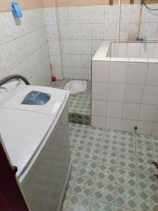 La salle de bains est pourvue d'un lavabo et de carrelage. dans l'établissement Villa Enos by GroRental, à Genteng