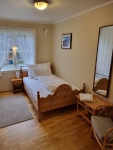 1 dormitorio con cama de madera y ventana en Rekkedal Gjestehus , Sæbø, en Ørsta