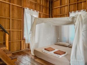 a bedroom with a bed with a mosquito net at Eve house koh kood in Ko Kood