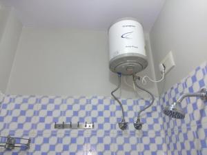 a bathroom with a blow dryer on the wall at Hotel zamarrud palace in Jaipur