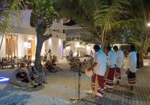 eine Gruppe von Leuten, die am Strand Schlagzeug spielen in der Unterkunft Stone Hotels Dhiffushi in Dhiffushi