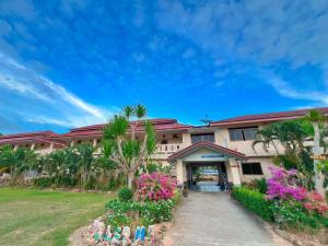 a building with palm trees and flowers in front of it at Diamond Beach Resort in Ao Nam Mao