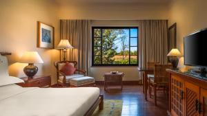 a hotel room with a bed and a desk and a window at Hyatt Regency Kathmandu in Kathmandu