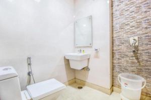 a bathroom with a toilet and a sink at Hotel Le Continental in New Delhi