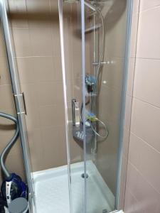 um chuveiro com uma porta de vidro na casa de banho em Spacieux studio confortable em Anzin