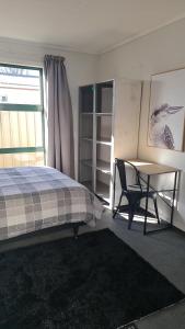 een slaapkamer met een bed, een bureau en een raam bij Tō Tātou Kainga in Blenheim