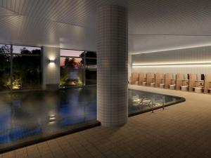 una piscina en un edificio con sillas y una piscina en Mercure Wakayama Kushimoto Resort & Spa en Kushimoto