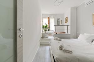 ein weißes Schlafzimmer mit einem Bett und einem Badezimmer in der Unterkunft BWR - Appartamenti in zona Sempione-Tre torri, via Alberti in Mailand