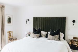 a bedroom with a large bed with black and white pillows at Coromandel Lodge, Berrima in Berrima