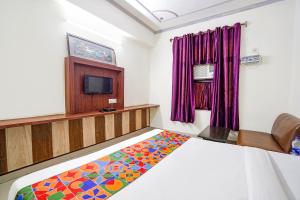 a bedroom with a bed and a tv in it at FabHotel Prashant Palace in Agra