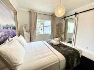 a bedroom with a large bed with a large window at Luxury White Beach House in Redondo Beach