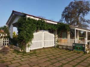 uma cerca branca em frente a uma casa em Singanama RESORT em Pachmarhī