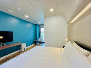 a bedroom with a large bed with a blue wall at 水秀一方Sun Moon Lakeside Boutique Hotel in Yuchi