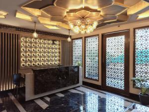 eine Lobby mit einem großen Kronleuchter und Fenstern in der Unterkunft Hotel Royal Lakshmi Palace in Jaipur