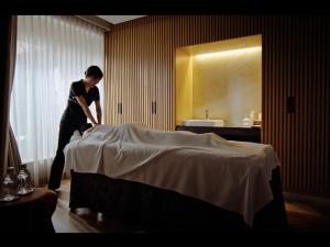a woman standing on a bed in a hotel room at Hotel The Celestine Tokyo Shiba in Tokyo