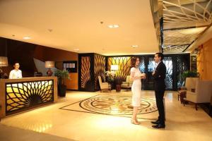 a man and a woman standing in a hotel lobby at Tracy Ben Thanh Tower in Ho Chi Minh City