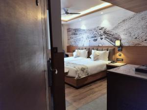 a bedroom with a bed with a painting on the wall at Hotel Royal Lakshmi Palace in Jaipur