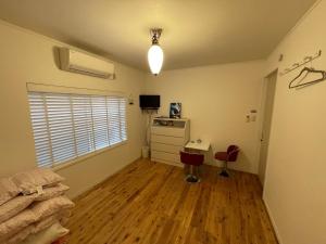 Zimmer mit einem Schlafzimmer mit einem Schreibtisch und einem Fenster in der Unterkunft VAMOS the Beach Front - Vacation STAY 05356v in Tokunoshima