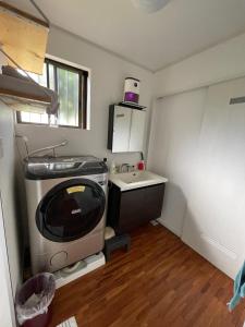 eine kleine Küche mit einem TV und einem Waschbecken in der Unterkunft VAMOS the Beach Front - Vacation STAY 05356v in Tokunoshima