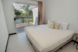 a bedroom with a bed and a large window at Villa Paraiso do Mar in Jacó