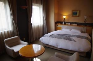 um quarto de hotel com uma cama, uma mesa e cadeiras em Gifu Castle Inn em Gifu