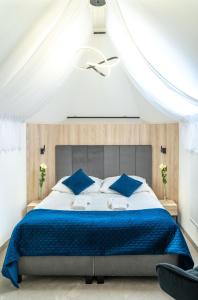 a bedroom with a large bed with blue pillows at Hotel Alpin in Szczyrk