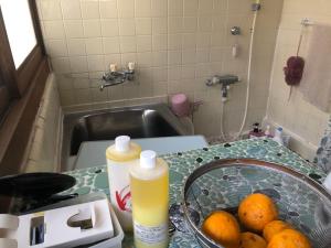 a kitchen counter with a sink and a bowl of oranges at 農家民宿　佐京園 in Shimada