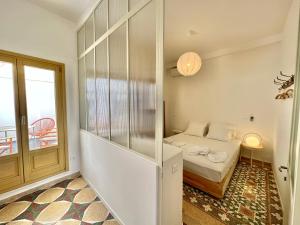a small room with a bed and a window at Port view apartment Aegina in Aegina Town