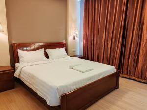 a bedroom with a bed with a book on it at Hotel Prima in Sandakan