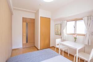 a bedroom with a bed and a table and a window at walk to JR Shibuya sta.-YoE10 in Tokyo