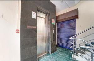 um elevador num edifício com uma porta azul em Trident INN gandhipuram em Coimbatore