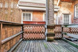 a wooden deck with a fence next to a building at Stylish 1br Unit Bella Vista By Center City in Philadelphia