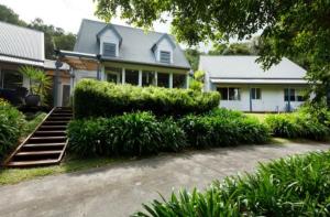a house with a lot of bushes in front of it at Quiet Country Retreat in Forster