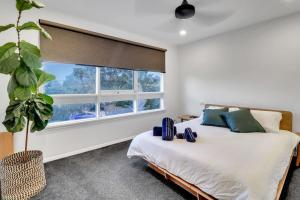 a bedroom with a bed and a large window at Sherbourne Retreat in Newtown in Geelong