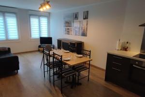 sala de estar con mesa y sillas y cocina en Appartement paisible proche gare, en Seclin