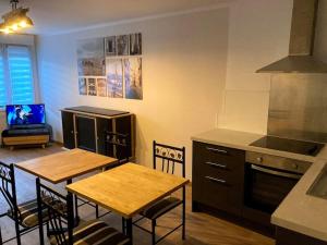 cocina con mesa y 2 sillas y cocina con fogones en Appartement paisible proche gare, en Seclin