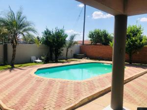 a small swimming pool on a brick patio at LOTUS LODGE in Gaborone