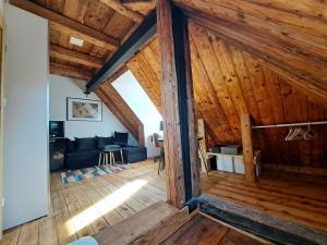 an attic room with wooden ceilings and a couch at Górskie apartmenty Kowary in Kowary