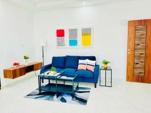 ein Wohnzimmer mit einem blauen Sofa und einem Tisch in der Unterkunft Olive Serviced Apartments BTM Layout in Bangalore