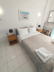 a bedroom with a bed and two tables with lamps at Atlas-Unlimited Sea View Apartment in Loutraki