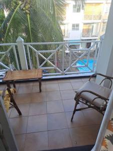 a dog sitting on a porch with a table and a chair at Le Residence Blue Bay in Blue Bay