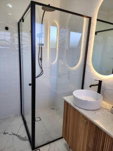 y baño con ducha y lavamanos. en Beautiful and cozy home, en Glenunga