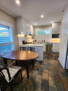 une cuisine avec une table en bois, une table et des chaises dans l'établissement Beautiful and cozy home, à Glenunga