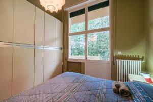 Schlafzimmer mit einem Bett und einem Fenster in der Unterkunft Trilocale Sporting con giardino privato e WiFi - Sunset Beach in Sirmione