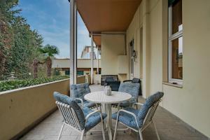 eine Terrasse mit einem Tisch und Stühlen auf dem Balkon in der Unterkunft Trilocale Sporting con giardino privato e WiFi - Sunset Beach in Sirmione