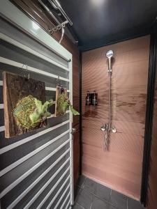La salle de bains est pourvue d'une cabine de douche et d'un mur en bois. dans l'établissement 鉄木彩虹小屋, à Yü-lan