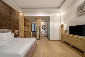 a bedroom with a large bed and a flat screen tv at Tashi Apartment in Da Nang
