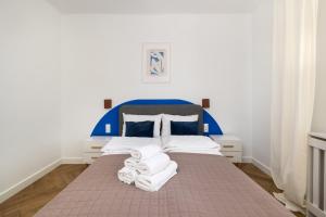 a bedroom with a blue and white bed with towels on it at ECRU Design Apartment in City Center WWA46 in Warsaw