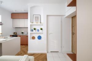 a kitchen with white cabinets and a white door at ECRU Design Apartment in City Center WWA46 in Warsaw