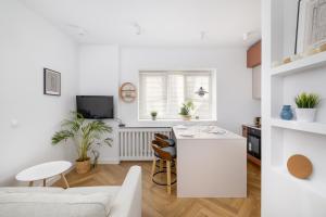 a white kitchen with a white island in a room at ECRU Design Apartment in City Center WWA46 in Warsaw